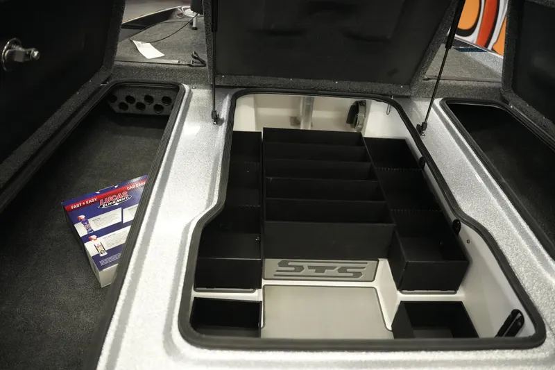 Slide: The Image of 2026 Bass Cat Lynx STS storage compartment with organized tackle boxes and accessories. - 21