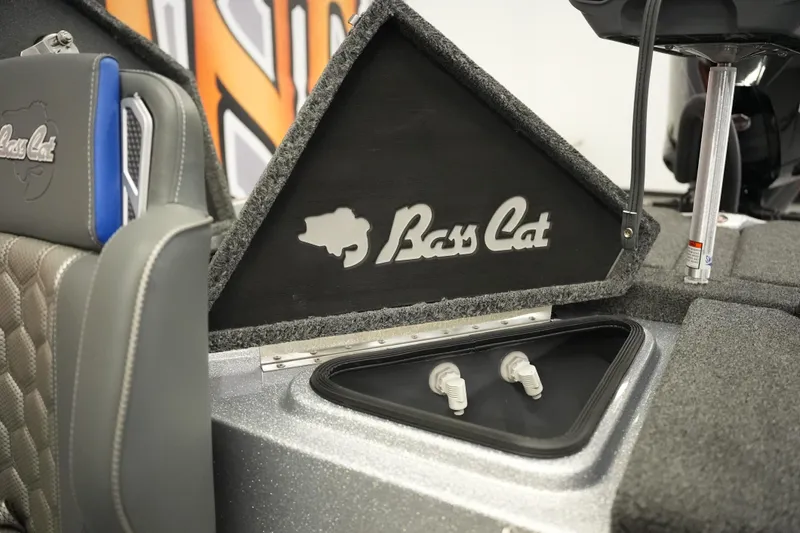 Slide: The Image of 2026 Bass Cat Lynx STS boat interior with logo and storage compartment. - 26