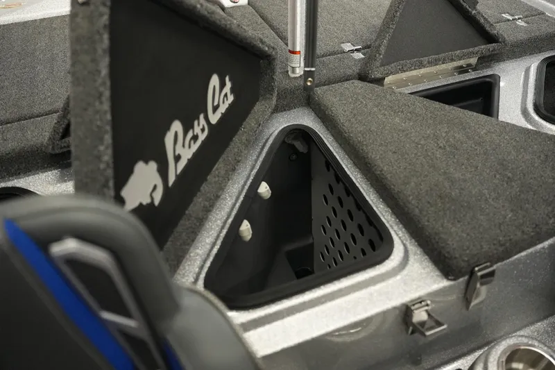 Slide: The Image of 2026 Bass Cat Lynx STS boat storage compartments with carpeted lids and logo. - 27