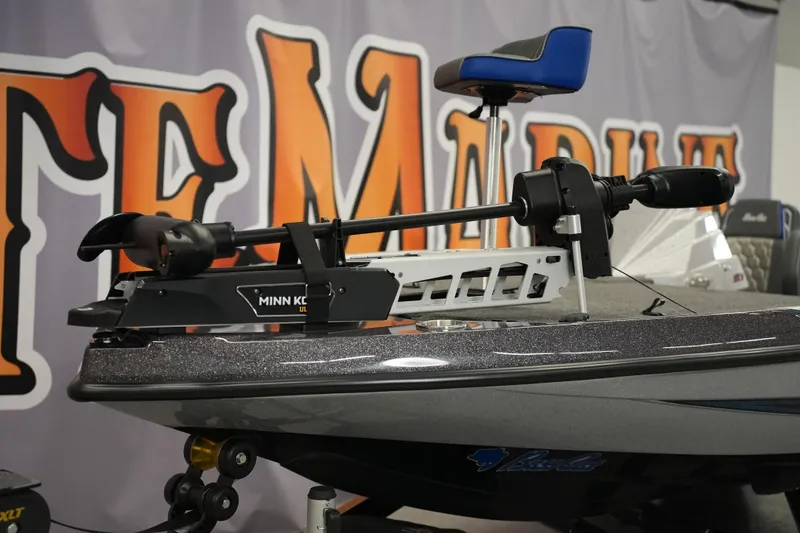 Slide: The Image of 2026 Bass Cat Lynx STS boat with Minn Kota trolling motor displayed indoors. - 8