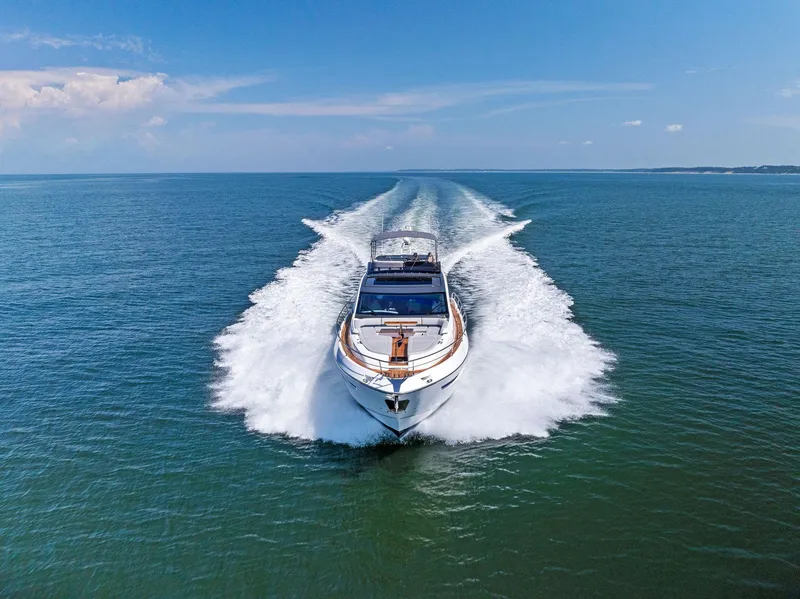Slide: The Image of 2024 Fairline Phantom 65 yacht cruising on open water, leaving a wake behind. - 3
