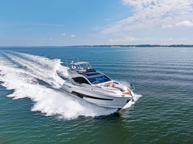 Slide: The Image of 2024 Fairline Phantom 65 yacht cruising on open water under a clear blue sky. - 4
