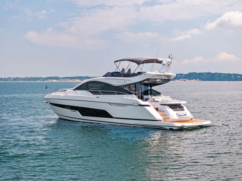 Slide: The Image of 2024 Fairline Phantom 65 yacht cruising on calm waters under a partly cloudy sky. - 5