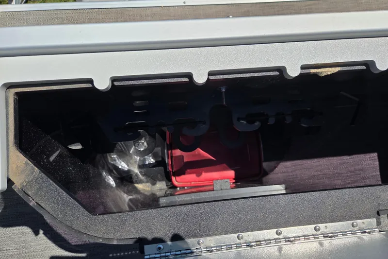 Slide: The Image of Storage compartment of a 2021 Godfrey Sweetwater 1880 FX boat, featuring a red container. - 14