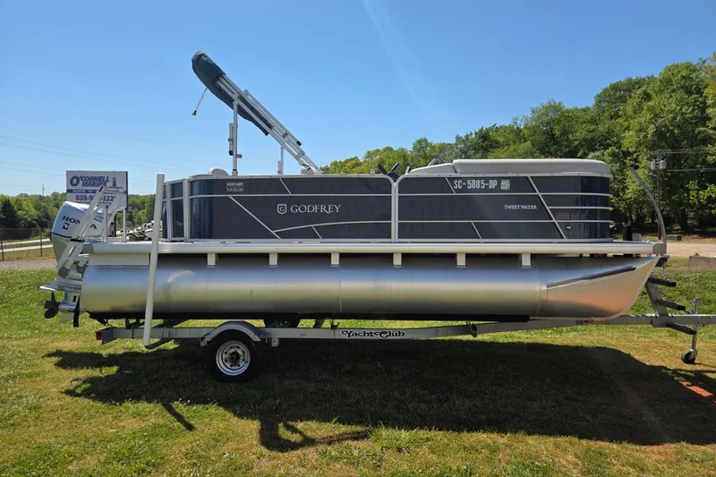 Slide: The Image of 2021 Godfrey Sweetwater 1880 FX pontoon boat on trailer, parked on grass. - 3
