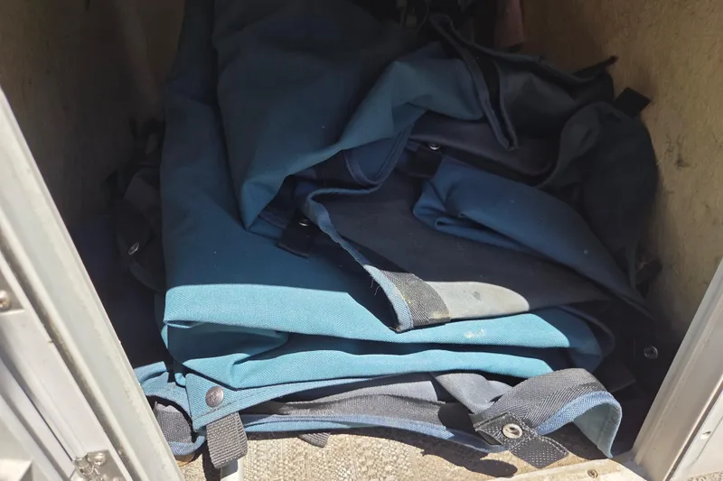 Slide: The Image of Folded blue fabric stored in a compartment of a 2021 Godfrey Sweetwater 1880 FX. - 9