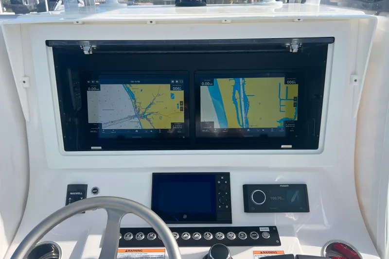Slide: The Image of 2024 Contender 35 ST boat dashboard with dual navigation screens and control panel. - 17