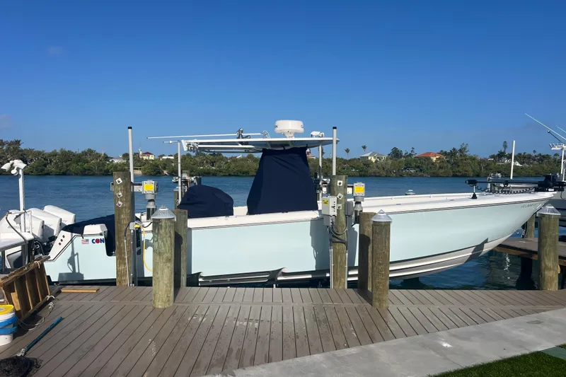 Slide: The Image of 2024 Contender 35 ST boat docked by a scenic waterfront under clear blue skies. - 3