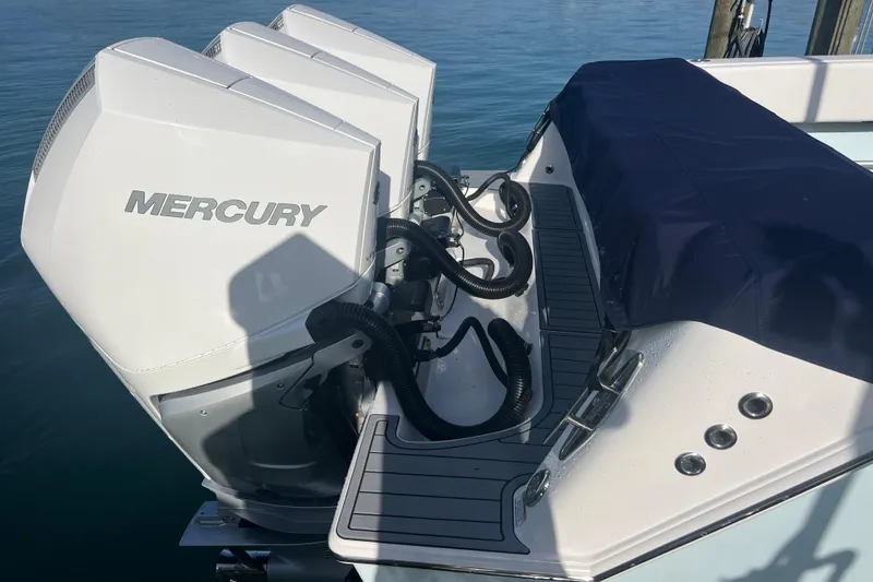 Slide: The Image of 2024 Contender 35 ST boat with Mercury outboard engines, docked on calm water. - 5