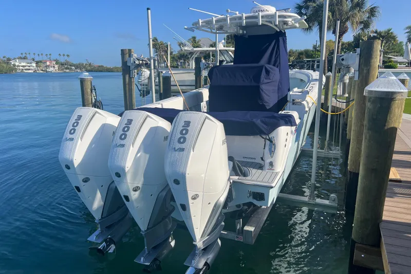 Slide: The Image of 2024 Contender 35 ST boat with triple 300 V6 engines docked by the water. - 6