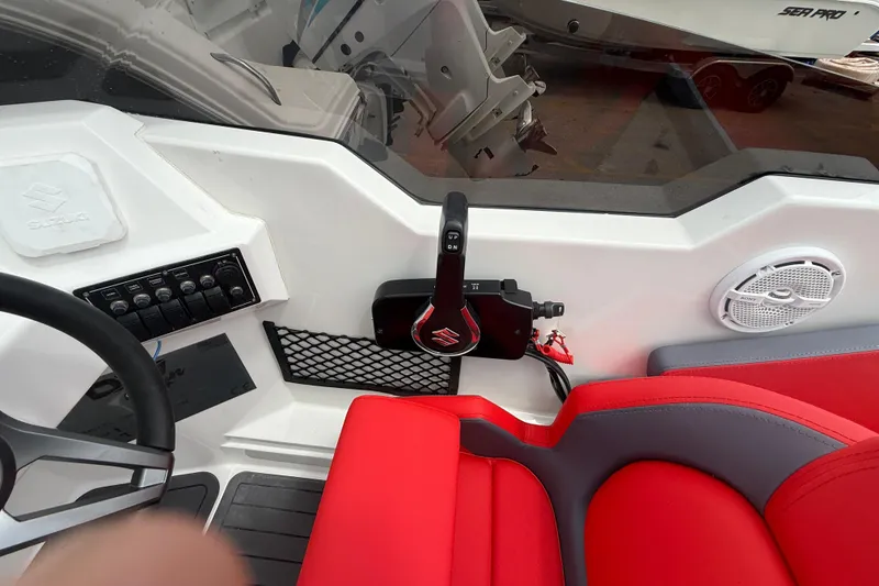 Slide: The Image of Interior of a 2025 Custom DW DESIGN 570BR boat with red seating and control panel. - 10