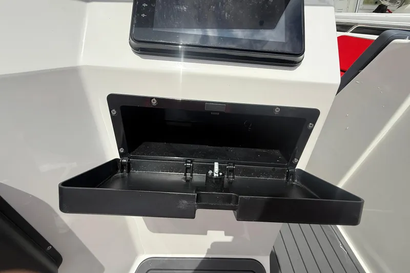 Slide: The Image of Open storage compartment on Custom DW DESIGN 570BR boat, featuring a sleek dashboard design. - 13