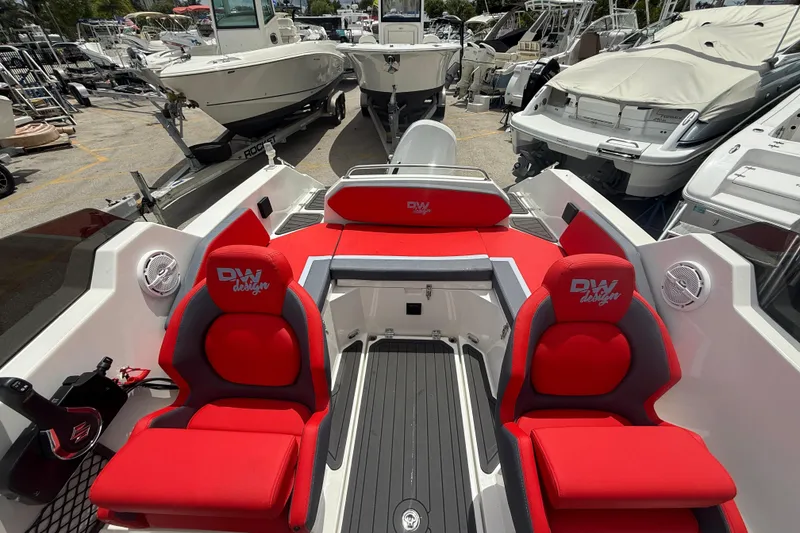 Slide: The Image of Red and gray seating on a 2025 Custom DW DESIGN 570BR boat, docked among other vessels. - 15
