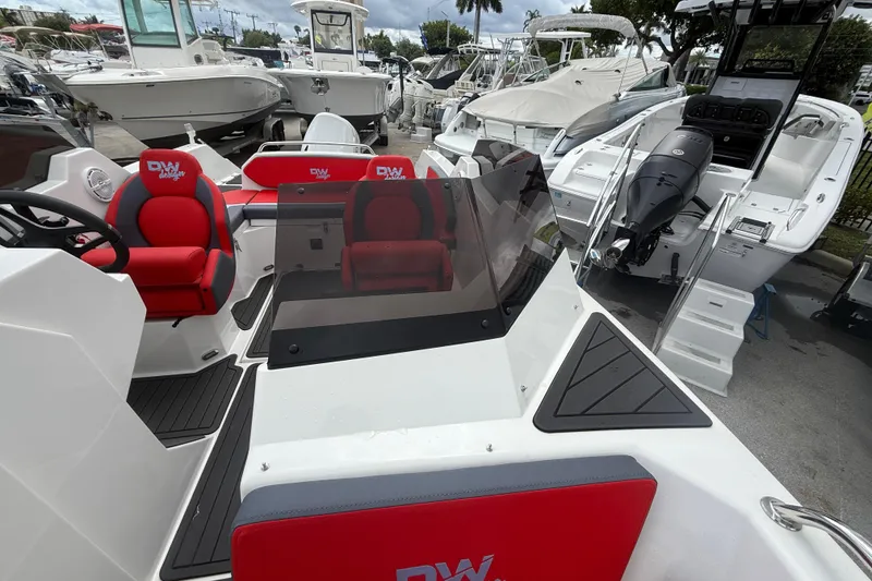 Slide: The Image of Custom DW DESIGN 570BR 2025 boat with red seating, docked among other boats. - 4
