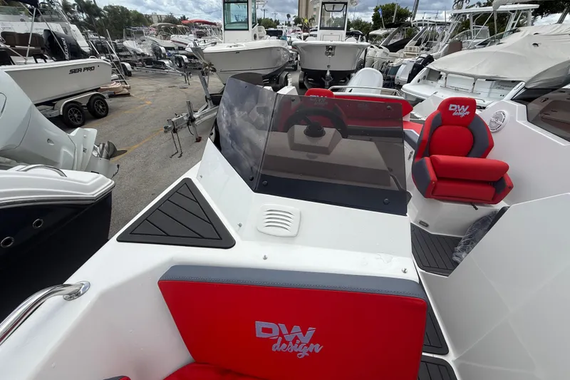 Slide: The Image of Custom DW DESIGN 570BR 2025 boat with red seating, docked among other vessels. - 5