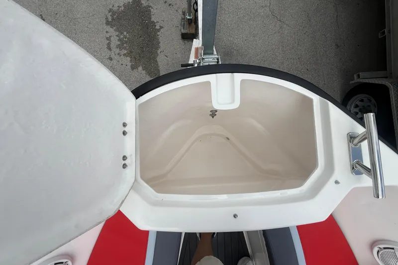 Slide: The Image of Open storage compartment on Custom DW DESIGN 570BR boat, 2025 model, with red and gray accents. - 7