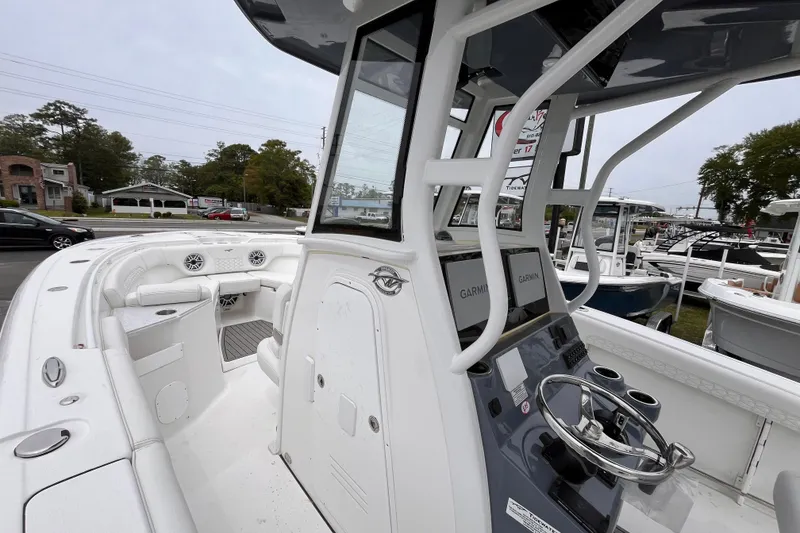 Slide: The Image of 2026 Tidewater 282 CC Adventure boat interior with helm and seating area. - 11
