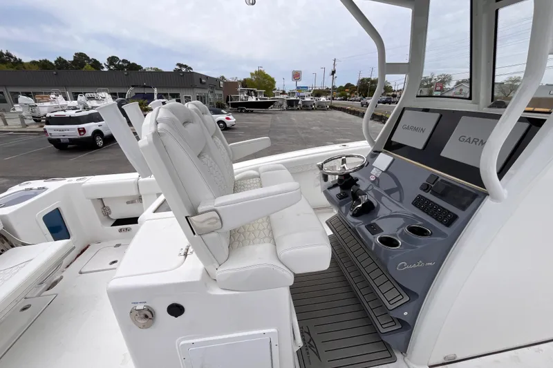 Slide: The Image of 2026 Tidewater 282 CC Adventure boat interior with dual Garmin displays and plush seating. - 18