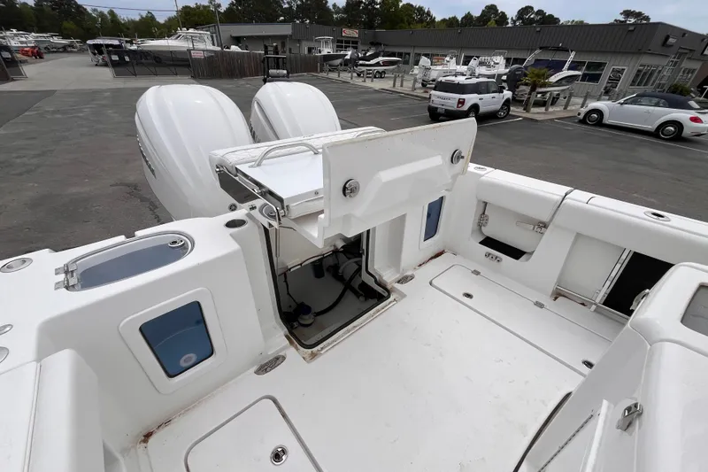 Slide: The Image of 2026 Tidewater 282 CC Adventure boat with open storage compartment and dual engines. - 19