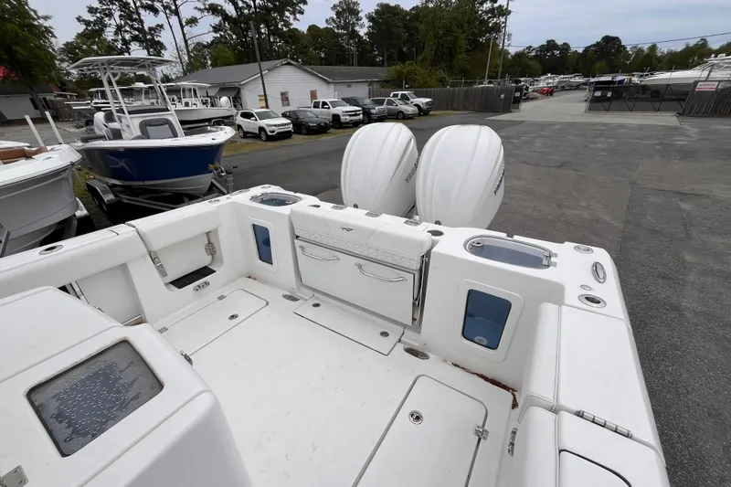 Slide: The Image of 2026 Tidewater 282 CC Adventure boat with dual engines, parked in a marina. - 6