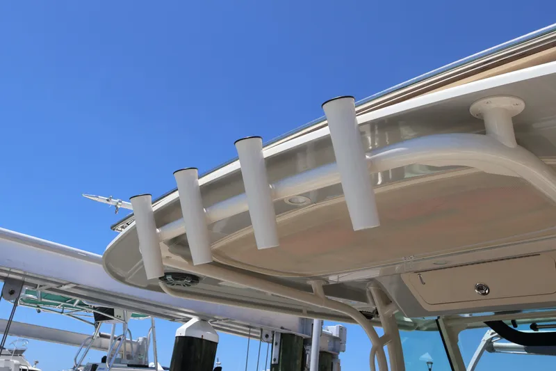 Slide: The Image of 2021 Grady-White Canyon 336 boat with rod holders against clear blue sky. - 47