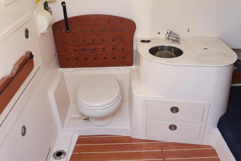 Slide: The Image of 2021 Grady-White Canyon 336 boat interior with toilet, sink, and storage drawers. - 57