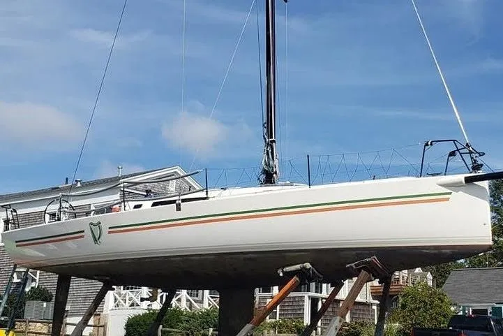 Slide: The Image of 2018 J Boats J/121 sailboat on dry dock, showcasing sleek design and vibrant stripes. - 64