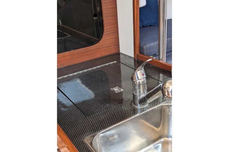 Slide: The Image of 2018 J Boats J/121 interior with sleek carbon fiber countertop and modern sink faucet. - 36