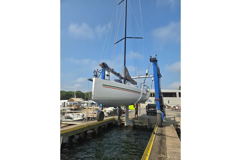 Slide: The Image of 2018 J Boats J/121 sailboat being lifted at a marina dock. - 2