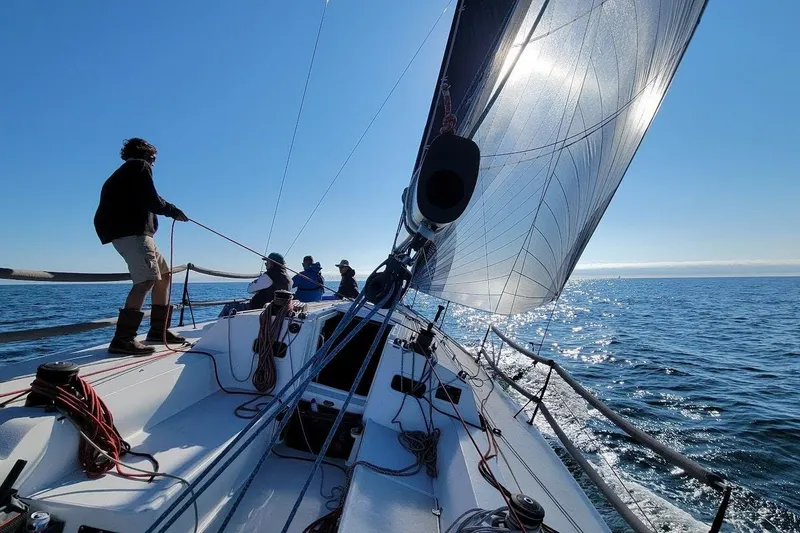 Slide: The Image of Sailors navigating a 2018 J Boats J/121 yacht on a sunny day at sea. - 6