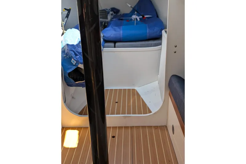 Slide: The Image of Interior of 2018 J Boats J/121 sailboat with wooden flooring and storage area. - 31