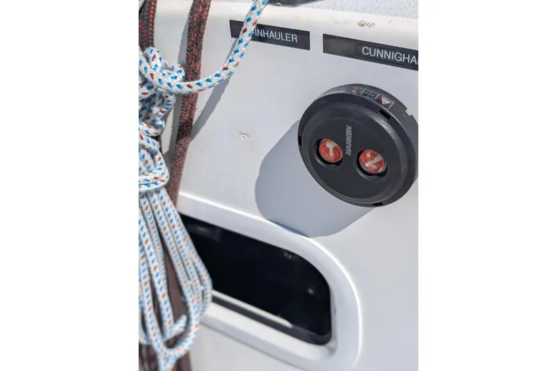 Slide: The Image of Close-up of J/121 sailboat rigging and control panel, featuring ropes and Harken equipment. - 51