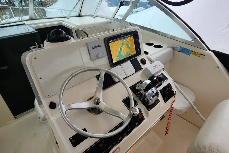 Slide: The Image of 2003 Pursuit 3070 Express boat cockpit with steering wheel and navigation system. - 13
