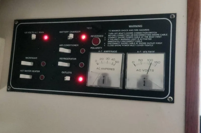 Slide: The Image of Electrical control panel on a 2003 Pursuit 3070 Express boat with switches and gauges. - 18