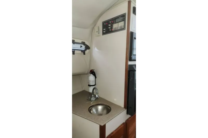 Slide: The Image of 2003 Pursuit 3070 Express boat interior with sink and control panel. - 21