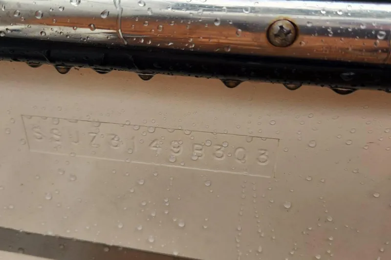 Slide: The Image of Hull identification number on a 2003 Pursuit 3070 Express boat, with water droplets. - 23