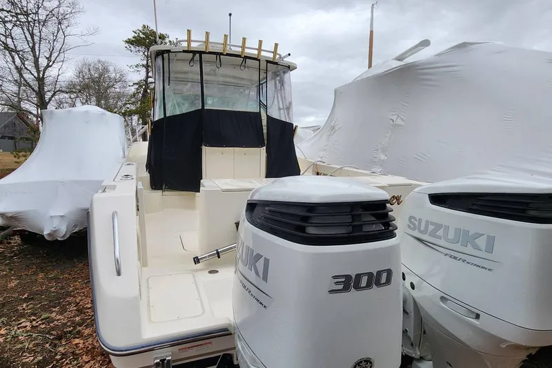 Slide: The Image of 2003 Pursuit 3070 Express boat with Suzuki 300 engines, stored outdoors. - 24