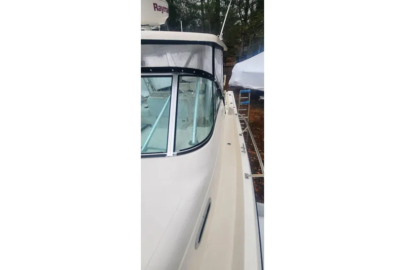 Slide: The Image of 2003 Pursuit 3070 Express boat side view with sleek design and clear windows. - 5