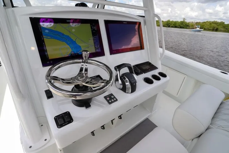 Slide: The Image of 2020 Yellowfin 39 Offshore boat dashboard with navigation screens and steering wheel. - 26