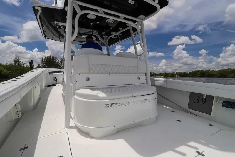 Slide: The Image of 2020 Yellowfin 39 Offshore boat interior with seating, under a blue sky with clouds. - 30