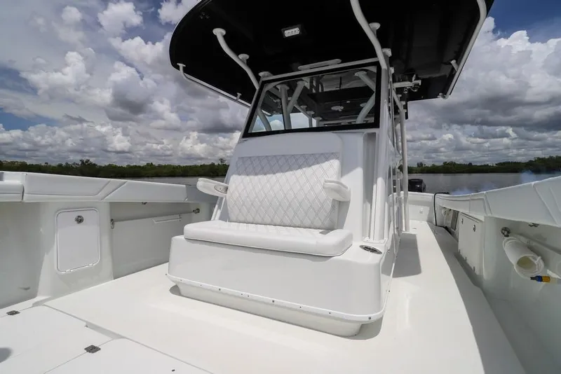 Slide: The Image of 2020 Yellowfin 39 Offshore boat with white seating and canopy under cloudy sky. - 32