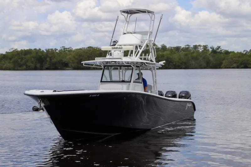 Slide: The Image of 2020 Yellowfin 39 Offshore boat on calm water with lush green background. - 7