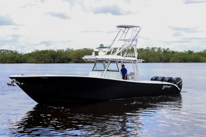 Slide: The Image of 2020 Yellowfin 39 Offshore boat on calm water with lush green shoreline. - 8