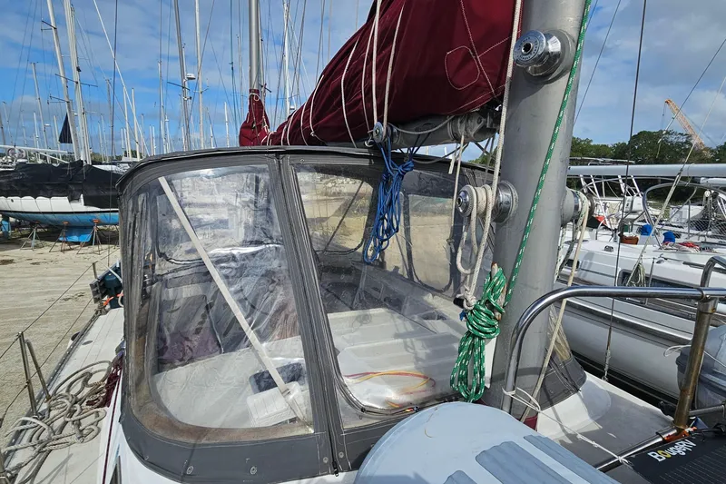 Slide: The Image of 1982 Morgan 462 sailboat with maroon sail cover, docked among other boats. - 19