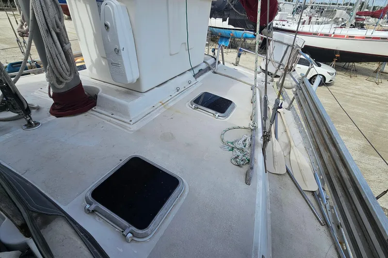 Slide: The Image of Deck of 1982 Morgan 462 sailboat with hatches and ropes in a marina setting. - 24