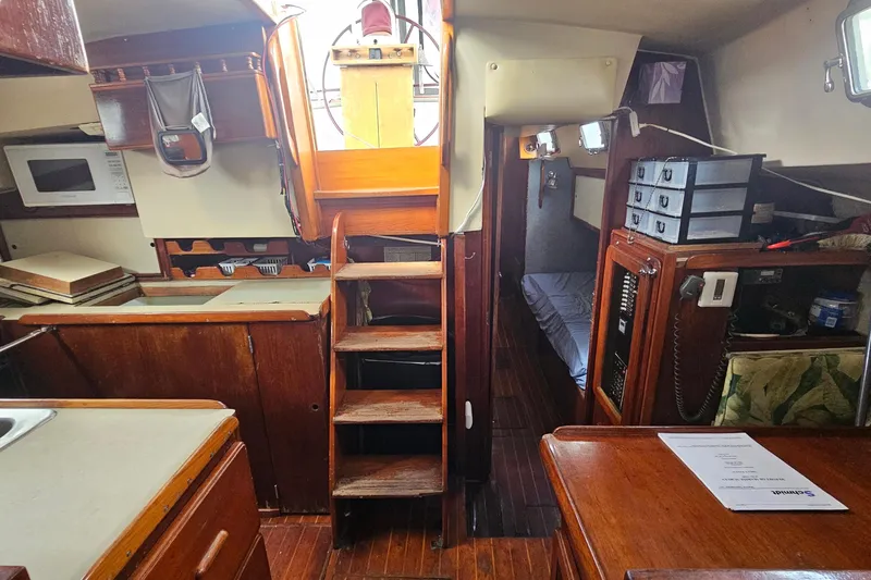 Slide: The Image of 1982 Morgan 462 yacht interior with wooden cabinetry, navigation station, and tropical-patterned seating. - 32