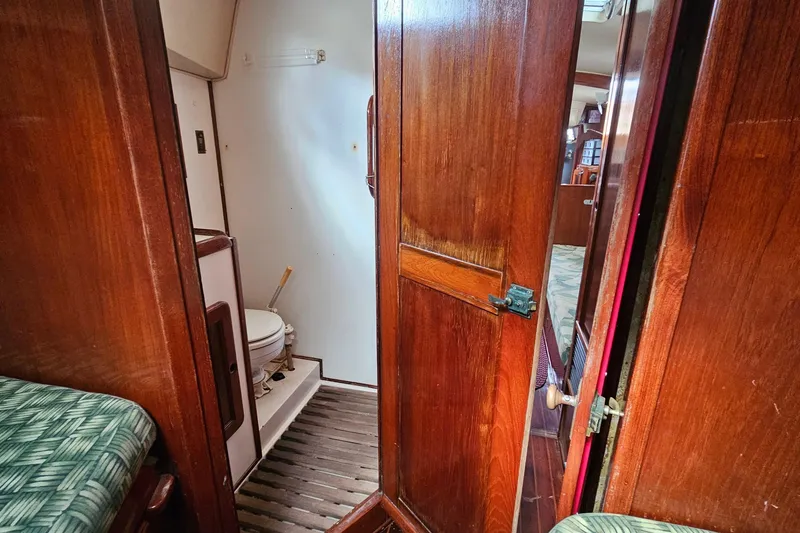 Slide: The Image of 1982 Morgan 462 yacht bathroom with sink and toilet, featuring wooden accents and compact design. - 44