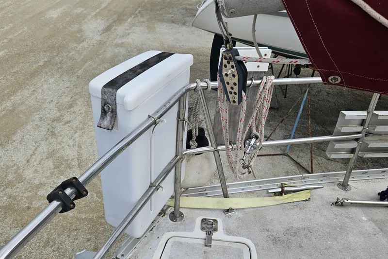 Slide: The Image of 1980 Morgan 462 sailboat with inflatable dinghy on deck, surrounded by lush greenery. - 67