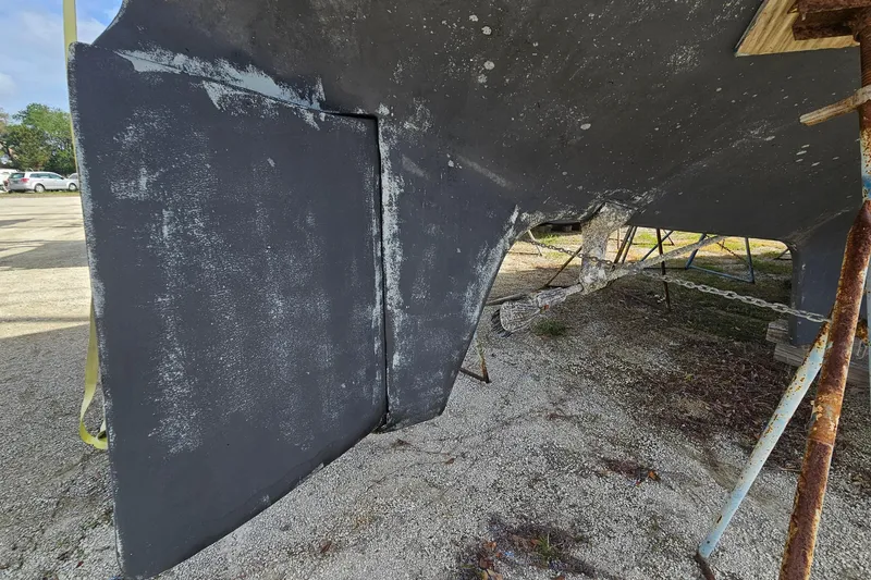 Slide: The Image of 1982 Morgan 462 sailboat hull and rudder in dry dock, showing wear and maintenance needs. - 7