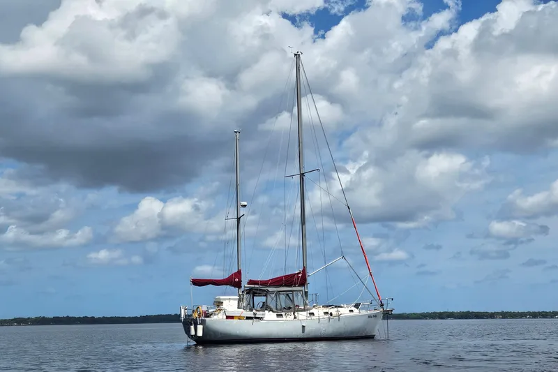 The Image of 1982 Morgan 462 sailboat on calm water under a cloudy sky. - 0